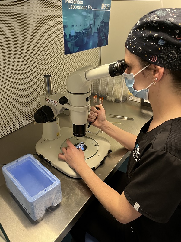 Imagen de una doctora analizando muestras en un microscopio